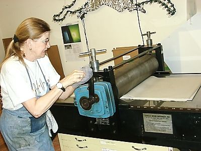 Janet cranks the press to pull the proof